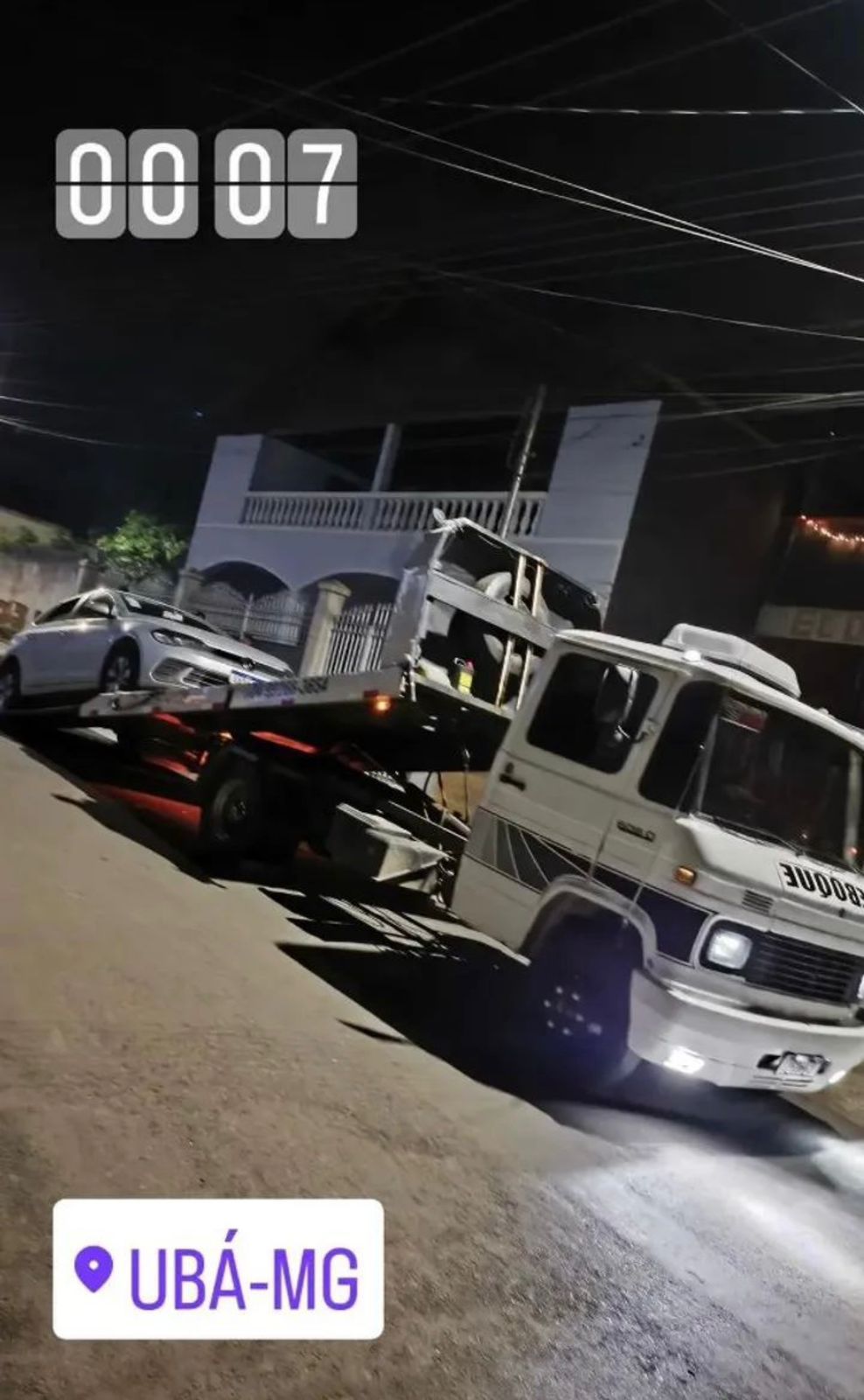 Guincho transportando carro à noite em via urbana
