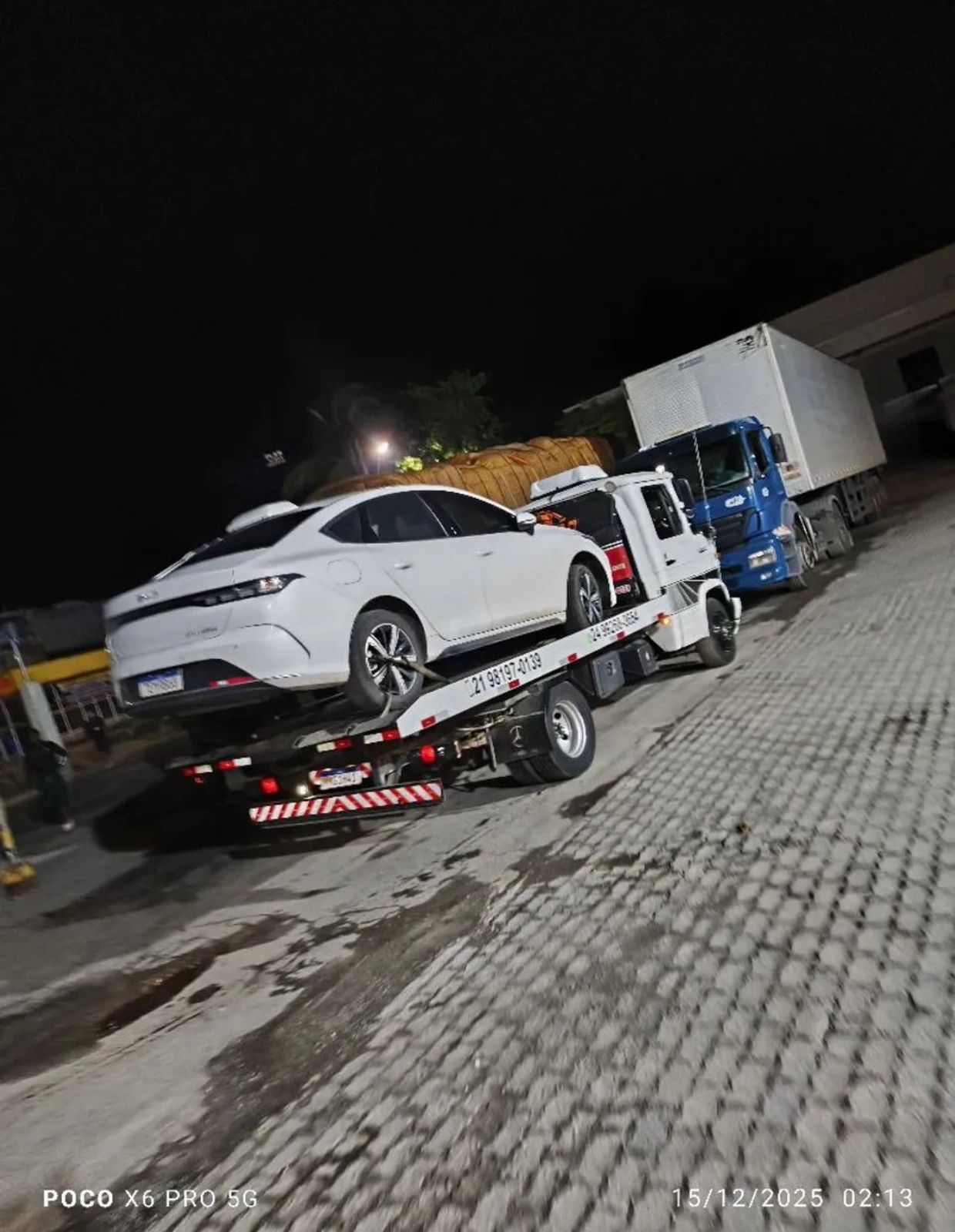 Guincho rebocando carro branco na madrugada